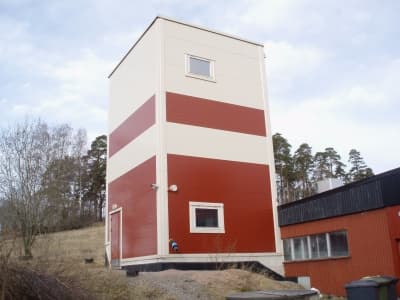 Jätevedenpuhdistamon prosessitorni Vihdissä — puna-valkoinen julkisivu, useita kerroksia