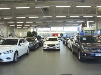 Delta-Autotalon näyttelyhalli sisältä — teräsristikot näkyvissä katossa, autoja esillä